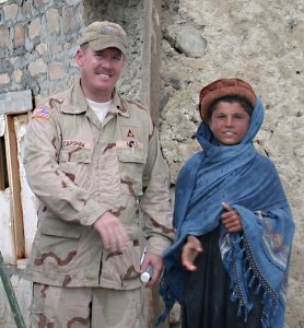 Phil Capshaw, now general manager at Hanscom AFB, Mass., teaching an Afghan boy how to shake hands the American way. 