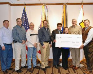 Michael Smietana, vice president real estate directorate presented Mike Immler, deputy director, with the Oncor rebate check along with (L to R) Gus Ellitott, vice president project management division; Keith Parker, HQ facility manager; David Combs, contract team leader; Matthew Cadwallader, RE project manager; Michael Zavis, energy project manager and Tina Martinez, admin business specialist.