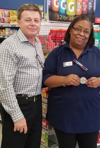 EVP/Chief Operating Officer Dave Nelson presents his coins to the Express’ Lawanda Adams at Fort Stewart, Ga.