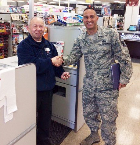 MCCONNELL AFB, Kan. - Senior Enlisted Advisor Chief Master Sgt. Luis Reyes presents his coin to Exchange cashier Nghi Le, who worked for the Army & Air Force Exchange Service in Vietnam during the war.