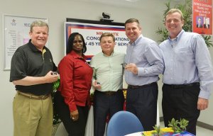 Patrick Air Force Base Exchange Store Manager Tamala McCoy presents Exchange leaders with special Patrick AFB coins to show appreciation for their visit after Hurricane Irma tore through the area. With McCoy, from left, are Director/CEO Tom Shull; Chief Operating Officer Dave Nelson; Aide to the CEO Sean Applegate; and Patrick Exchange General Manager James Clark.