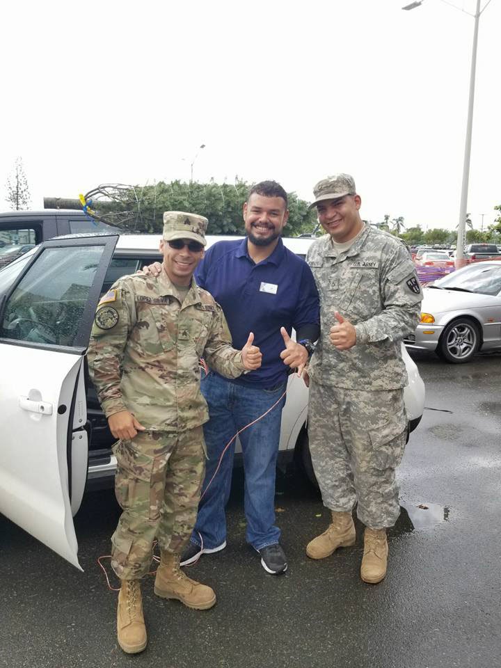 Customers receive help for an associate as they tie the tree on their car.