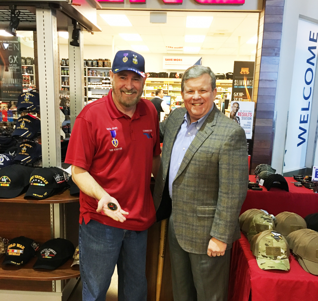 Retired Navy Master Chief Petty Officer Larry Van Schuyver receives a coin from Director/CEO Tom Shull during a recent visit.