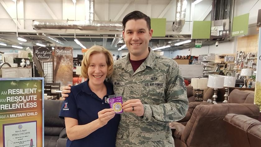 During the Month of the Military Child, RAF Mildenhall Exchange's Susan Kolbe presents a Military Brat patch to her son, Jonathan. Jonathan is stationed 10 miles away at RAF Lakenheath. Both installations are in the United Kingdom.