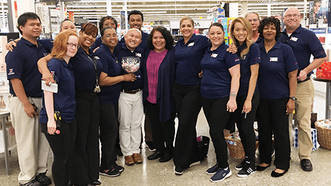 President and Chief Merchandising Officer Ana Middleton, center, stands with Fort Meade associates, who received her coins for getting glowing customer comments.