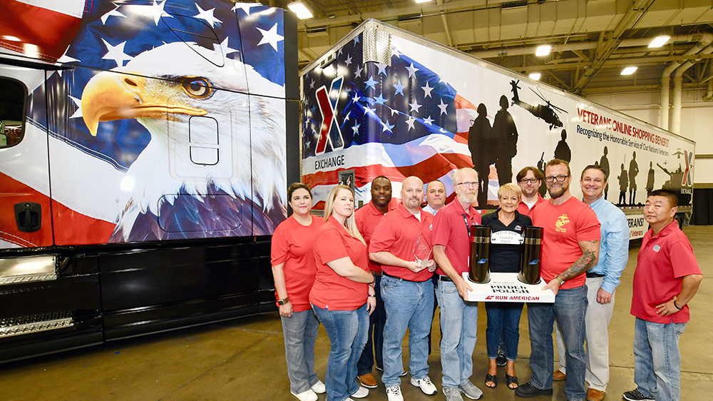 Members of Corporate Communication and the Logistics Directorate hold the big prize in front of the Exchange truck.