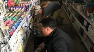 Sherri Rinker and Ronnie Palencia remove damaged merchandise from the shelves.