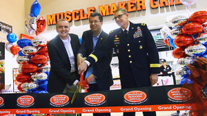 Fort Sill Exchange general manager Don Walter Jr.; Mike Roper, Muscle Maker Grill CEO; and Maj. Gen. Wilson A. Shoffner, Fort Sill commanding general, cut the ribbon to open Muscle Maker Grill Nov. 21.