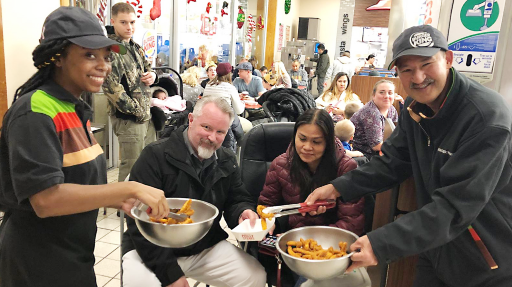 MISAWA AB, Japan - Burger King associates Jayla Wood and Freddie Figuracion hand out samples of Chicken Fries to hungry participants during the food court's big Bingo night.