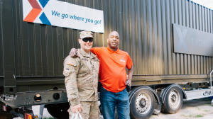 Associate and Soldier standing in front of an MFE in Poland. Illustrates Exchange relevancy.