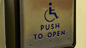 A push to open door sign showing a wheelchair icon.