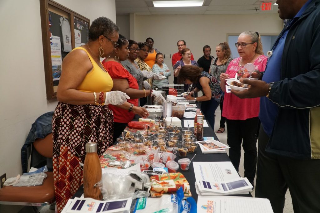 Members of BRIDGE serve cultural food samples to associates at Exchange HQ. 