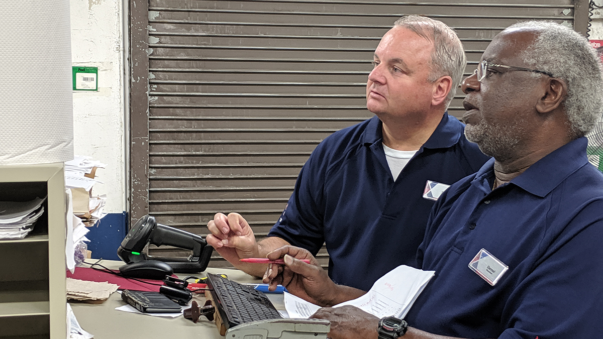 At MacDill AFB, Scott Laschkewitsch, left, and Stockroom Receive Dil Cannon pore over warehousing procedures. processes.