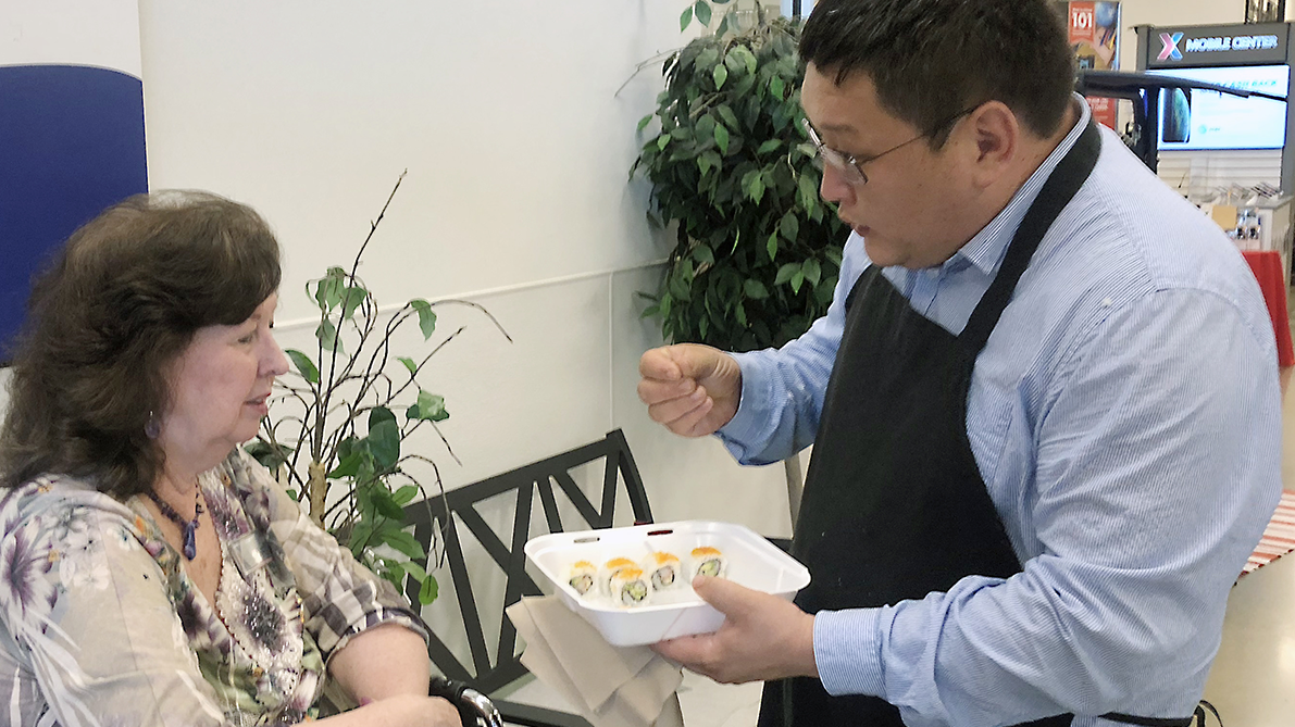 LITTLE ROCK AFB, Ark. - Odbayar "Ocko" Ulziibuyan, owner of Ocko's Sushi Bar, offers samplings of his food to a customer. Ocoko's restaurant opened Aug. 5 in the food court. The restaurant offers California rolls, spicy crawfish rolls, crunchy shrimp and more. “The Little Rock Exchange is committed to bringing healthy, BE FIT dining options to Airmen and families,” said Exchange General Manager Donald Cantwell. “We’re excited to bring more choices to the community.”