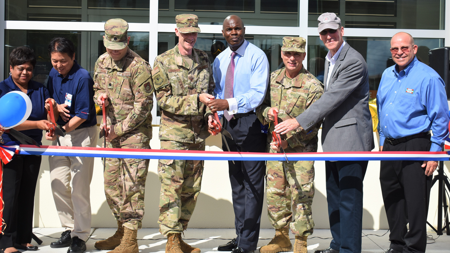 Pacific Region Commander Col. Scott Maskery and Exchange General Manager Antonio Porter, both center, help cut the ribbon on Kadena AB's new Express.