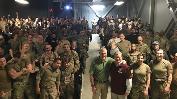 Director/CEO Tom Shull, in red shirt, and Ken Caldwell of The Walt Disney Studios join troops in Afghanistan for the showing of the new "Star Wars" movie.