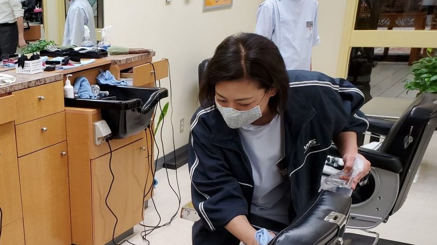 An Exchange barber at Japan's Misawa AB cleans a chair after a customer had just left.