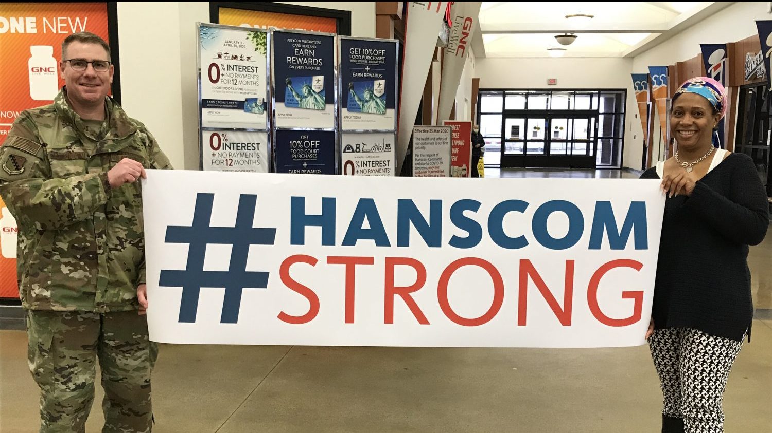 Hanscom AFB Commander Col. Chad Ellsworth and Exchange HR recruiter Nora Pile display a banner on April 3 Hanscom Strong Day.