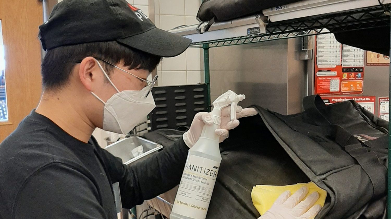 Camp Humphreys Exchange food service worker Han Sang-uk sanitizes a Pizza Hut delivery pouch. 