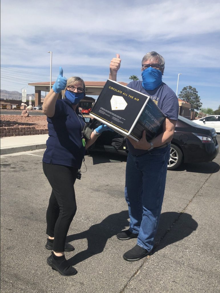 From left, Nellis Air Force Base Exchange Customer Service Supervisor Gisela Jameson meets shopper Daniel Borkowski in the parking lot of the base’s visitor’s center to deliver his buy online, pickup in store order.