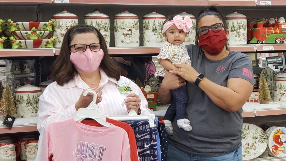 Exchange shopper Martha Alaniz and granddaughter Jolina Tynes pick up winter clothes for Alaniz's three grandchildren Oct. 14 at the Fort Hood Exchange. Alaniz was one of 52 lucky shoppers notified this week that their Exchange layaway balances were paid in full by the nonprofit Pay Away the Layaway. Also pictured, Fort Hood Main Store Manager Teresa Palu.