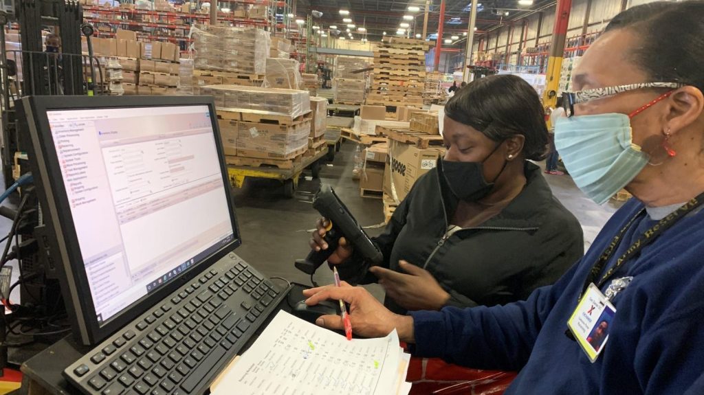 From left, Receiver Alicia Wilson and Materials Handler Profile Leader Catherine Porter check merchandise into the Dan Daniel Distribution Center using the new JDA warehouse management system.