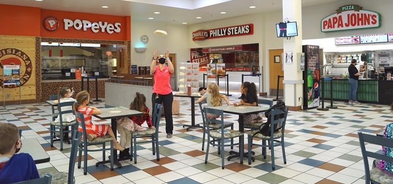 Laure Sylvia of Papa John's Pizza demonstrates her dough-tossing technique at a "How to Make a Pizza" party at the Davis-Monthan Air Force Base Exchange.