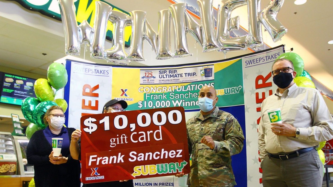 Staff Sgt. Frank Sanchez holds his symbolic Exchange gift card at the Fort Sill Main Exchange food court. Lori Allen, Exchange food court manager, Subway manager Cynthia Curtis and Fort Sill Exchange General Manager Don Walter are also pictured. (Photo courtesy of the Fort Sill Tribune)