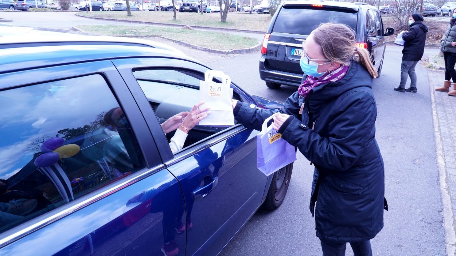 Kaiserslautern Military Community Center Exchange Associate Yvonne Murph hands out goody bags during a two-day Purple Up drive-up event April 15 and 16, in celebration of Month of the Military Child at Ramstein Air Base, Germany. (U.S. Army photo by Sgt. 1st Class Taresha Hill)