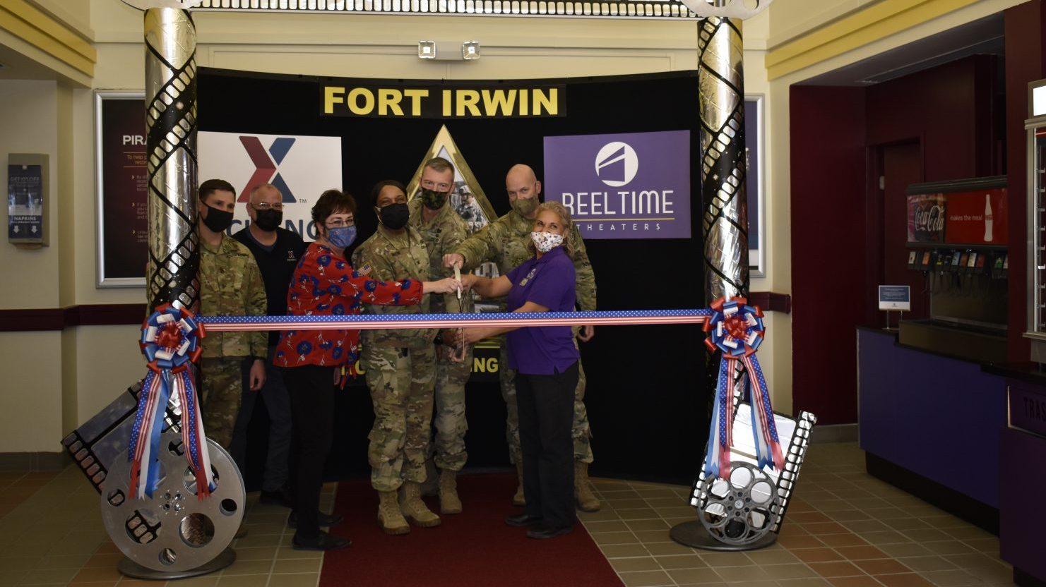 Fort Irwin PX General Manager Holly Elliott (left) and Theater Manager Mercedes Garcia (right), along with Garrison Commander Col. Jeanette Martin, cut the ribbon on the newly renovated Reel Time Theater, which reopened in March.