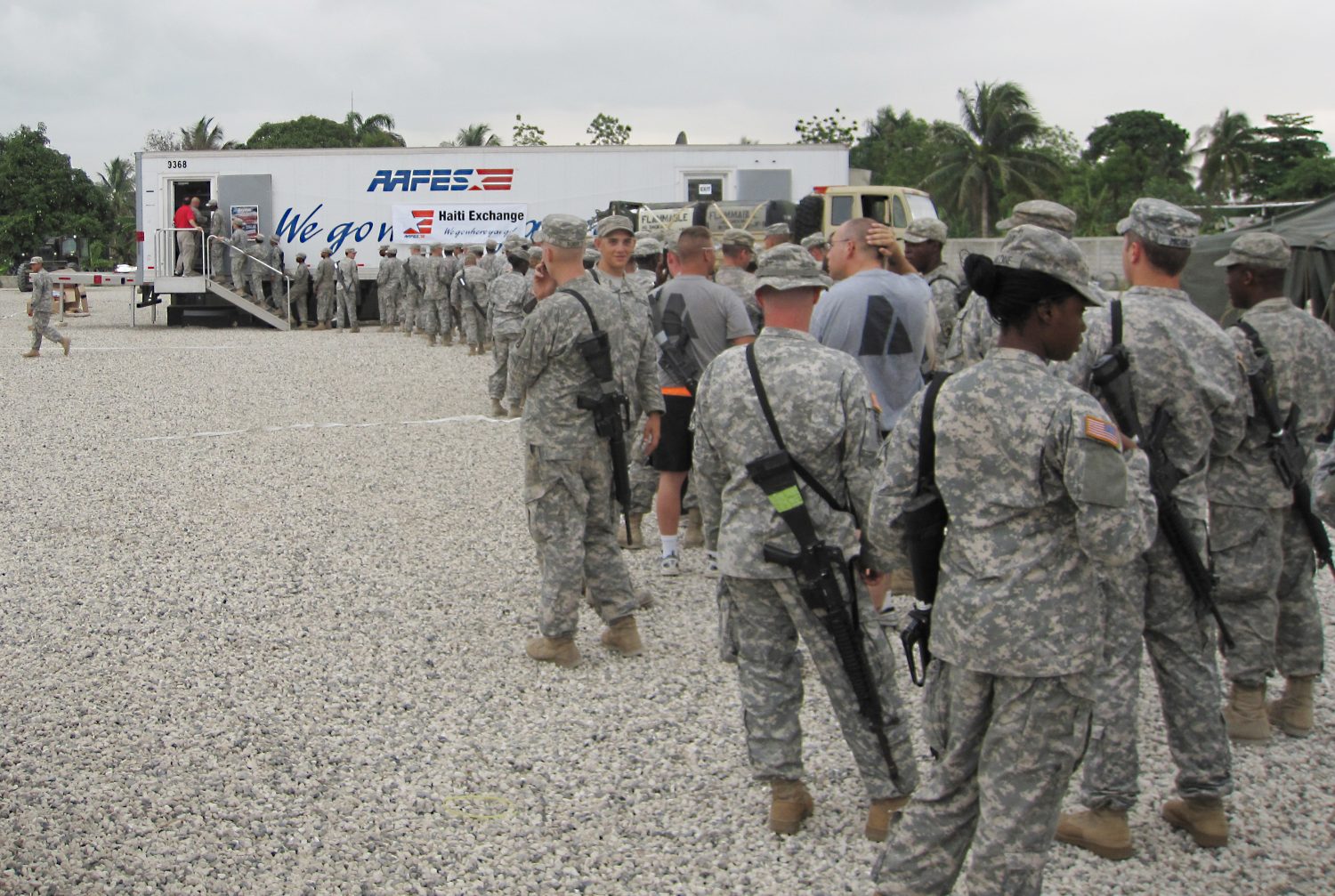 Soldiers supporting recovery efforts in Haiti after the 2010 earthquake line up at  a mobile field exchange.