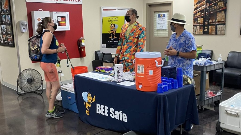 Guy Pelland, in the orange suit, and Fernando Millan of Loss Prevention talk with Leisa Williams, a a materials handler at the Waco Distribution Center, about heat awareness during Wednesday's "Stay Hydrated" heat-awareness event at the Waco DC.