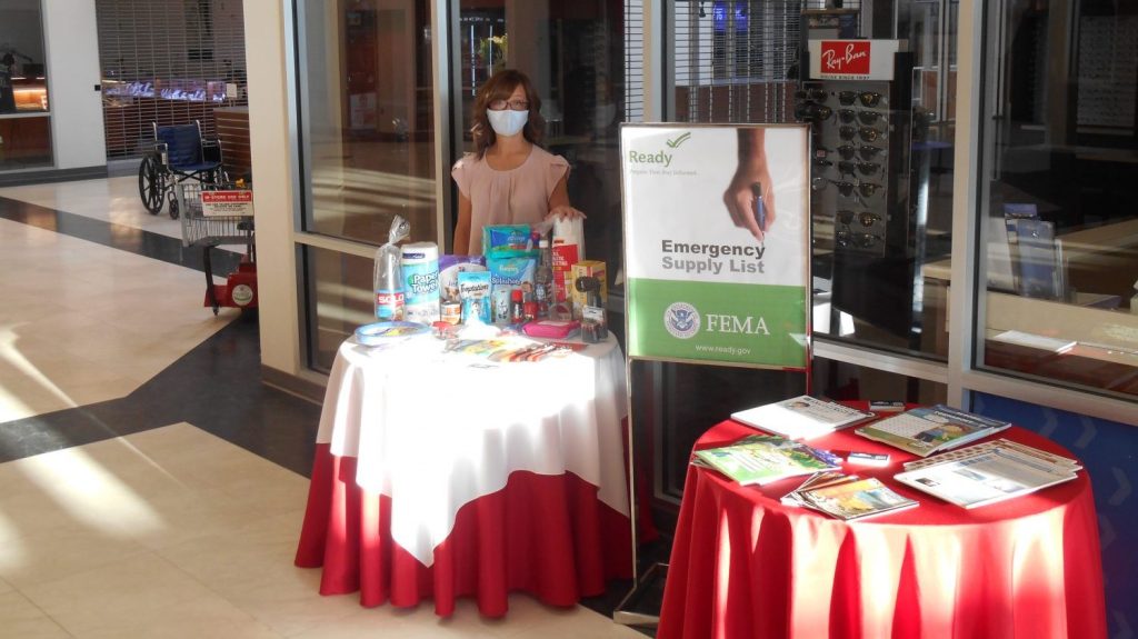 <strong>Julie Gregory, services business manager at the Offutt Air Force Base Exchange, works at a display during a base event for Preparedness Month (September) held at the Exchange. 
The base provided informational pamphlets and the Exchange provided items that could be purchased for emergency safety kits. </strong>
