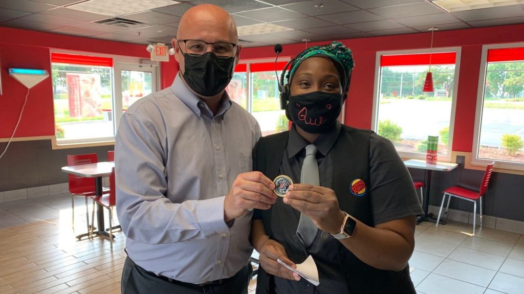 COO Jason Rosenberg presents his coin to Qianna Carr, manager of the Aberdeen Proving Ground Burger King. Despite challenges, Carr has led her team through a tremendous operayional improvement in the past year. "She is a great exam[;e of leading through adversity," Rosenberg said.