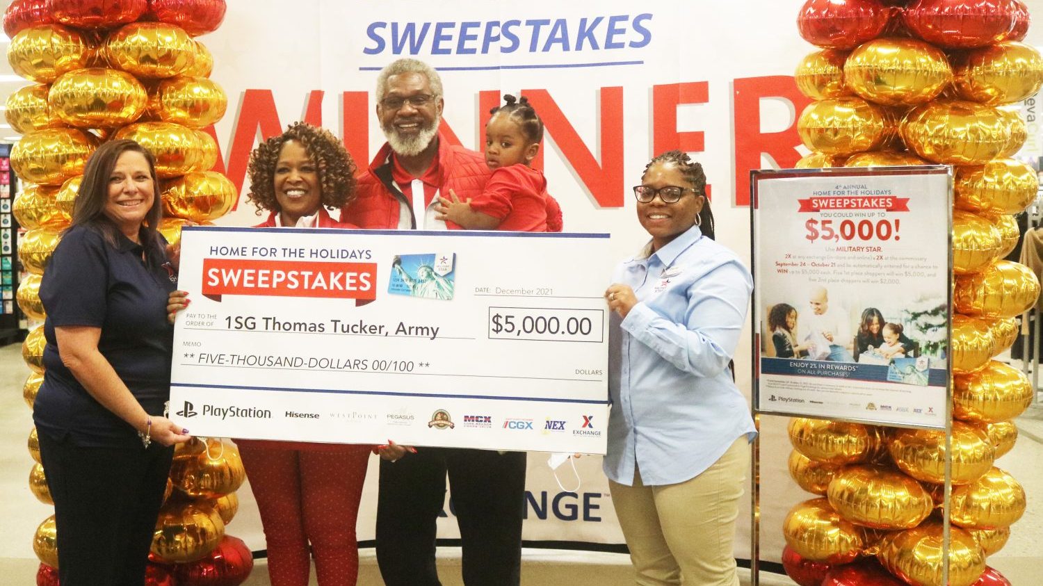 Redstone Arsenal Exchange General Manager Sheila Enderle (left) and Main Store Manager Chantel Scott (right) present retired Army 1st Sgt. Thomas Tucker with an oversized $5,000 check, the grand prize in the MILITARY STAR Home for the Holidays sweepstakes, Dec. 20 at the Redstone Exchange.