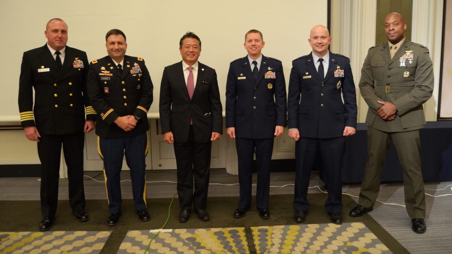 (Left to Right) On March 4 Navy Capt. Patrick Dziekan, Fleet Activities Okinawa; Army Col. Christopher Paone, 10th Support Group; Tony Sakuda, AmChamp Okinawa President; Air Force Col. Jason Kane, 18th Mission Support Group; Col. Michael Kovalchek, AAFES Pacific Region Commander, Marine Corps Col. Henry Dolberry Jr., Marine Corps Air Station-Futenma pose for a picture after the American Chamber of Commerce-Okinawa annual Commander’s Panel at the Laguna Beach Hotel. Each commander detailed their command’s missions and emphasized the importance of maintaining good community relationships among both U.S. service members and the local community. AmCham Okinawa is a non-profit organization made up of more than 150 corporate and government members from American and Okinawan business communities to connect members through networking events, business and government seminars to help create contacts and develop business relationships. (U.S. Army Photos by Staff Sgt. Mark A. Kauffman)

