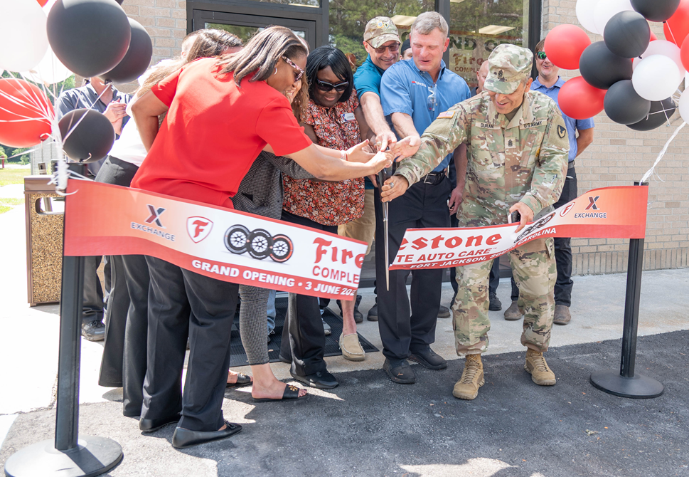 <b>Brig. Gen. Patrick R. Michaelis, post commanding general (obscured), Garrison Command Sgt. Maj. Cesar Duran (far right), Kimberly Neiss, Exchange general manager (third from left, partially obscure), and others cut the ribbon on the Fort Jackson Firestone Complete Auto Care on June 3. (Alexandra Shea/Fort Jackson Public Affairs Office)<b>