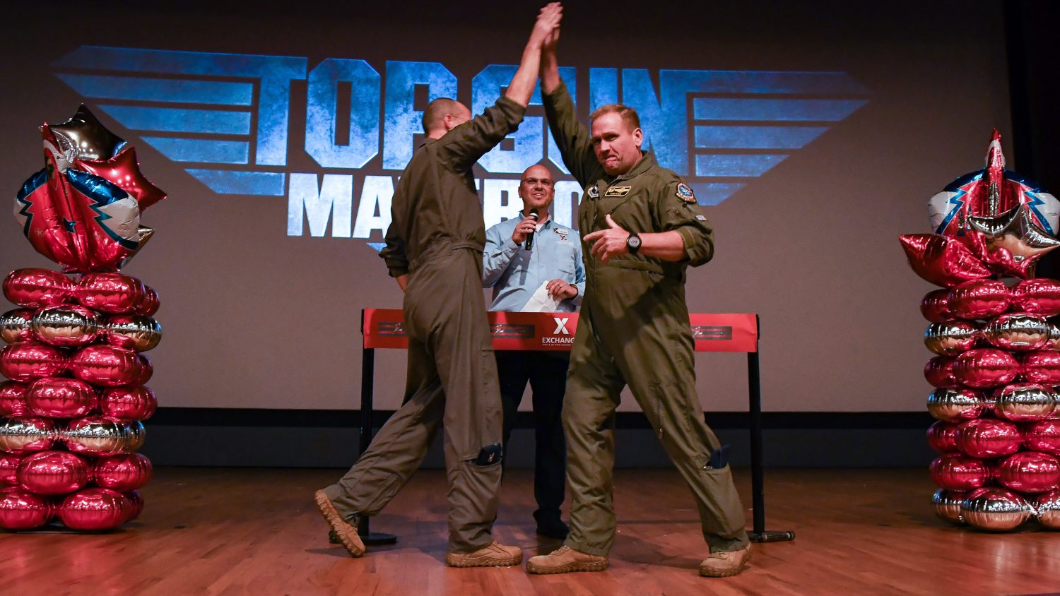 <b>Col. Robert J. Haas Jr. (right), 80th Flying Training Wing commander, and 80th FTW Vice Commander Col. Scott A. Gunn re-enact a scene from the original "Top Gun" at a "Top Gun: Maverick" screening at Sheppard AFB's Reel Time Theater as Sheppard General Manager Mikel Hunter looks on. The late-May screening was the first move shown at the theater in 2 1/2 years. (U.S. Air Force photo by John Ingle)<b>