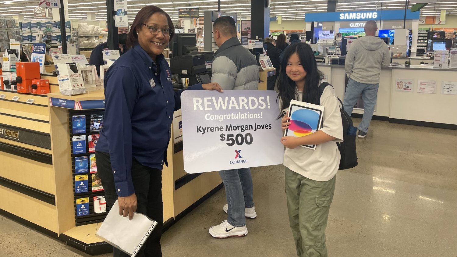 <b>Debra Melton, Camp Humphreys main store manager, with Kyrene Morgan Joves, a fourth-grade student at Central Elementary School, Feb. 3 after Kyrene spent time in the PowerZone picking out her new IPad. Kyrene was the $500 third-place winner in the You Made the Grade Sweepstakes that was held in December. 