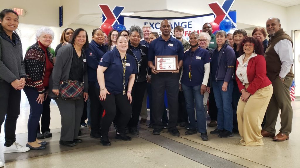 <b>Fort Bragg Exchange teammates celebrate Michael Lee, Military Clothing store manager, after he received an award for going out of his way to help a customer with a last-minute request.</b>