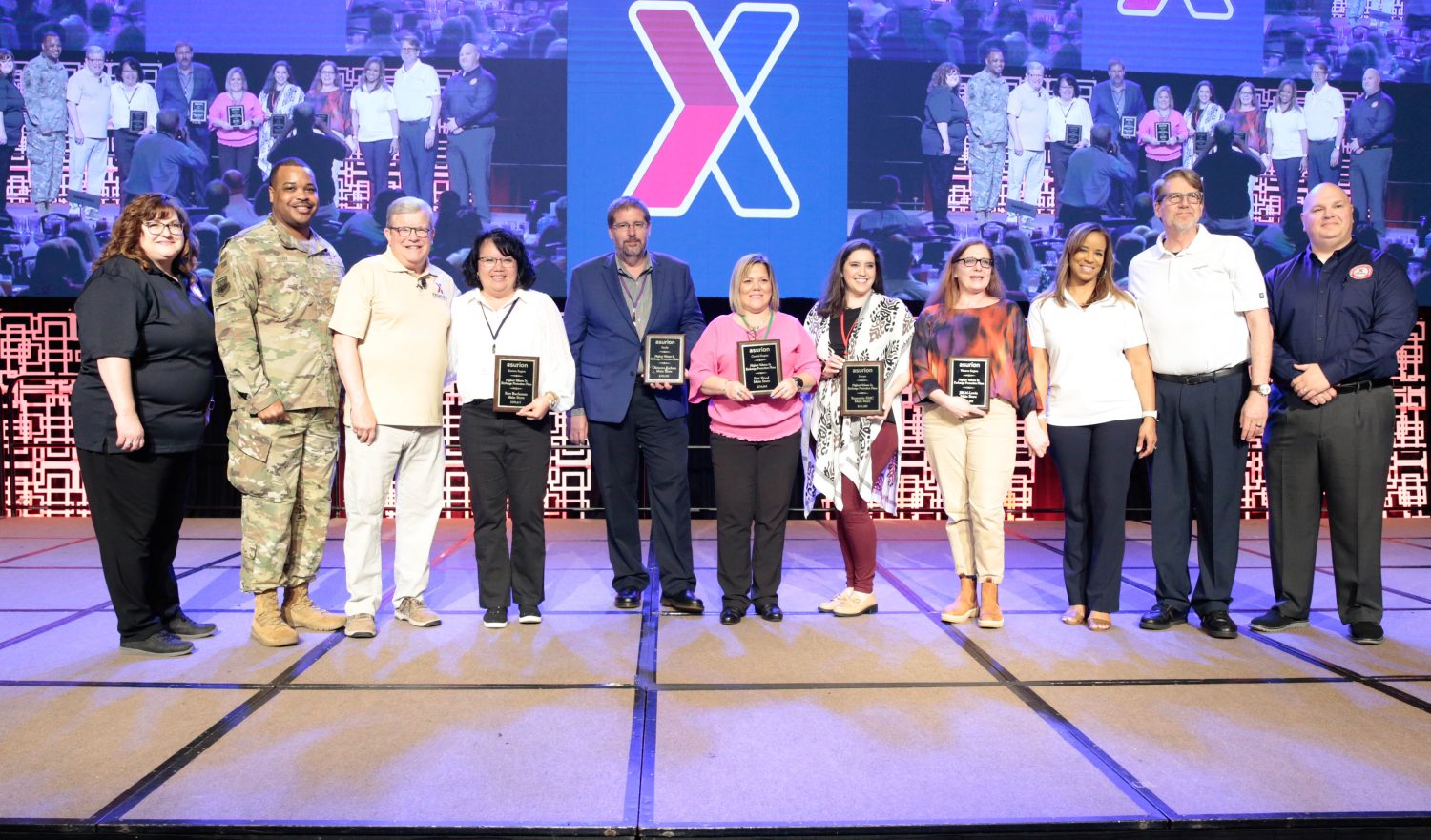 Central region store managers accept their Exchange Protection Plan awards from Asurion and the merchandising directorate. From left: Karen Cardin, executive vice president and chief merchandising officer; Chief Kevin Osby, Exchange senior enlisted advisor; Director/CEO Tom Shull; Alexandria Miner, store manager, Scott AFB; Tonya Yancey, store manager, Fort Polk; Cynthia Gregg, store manager, Wright-Patterson AFB; Asurion representatives; and Eric Sidman, senior vice president, merchandising. (Photo courtesy of Exchange Photographer Ross Hailey)