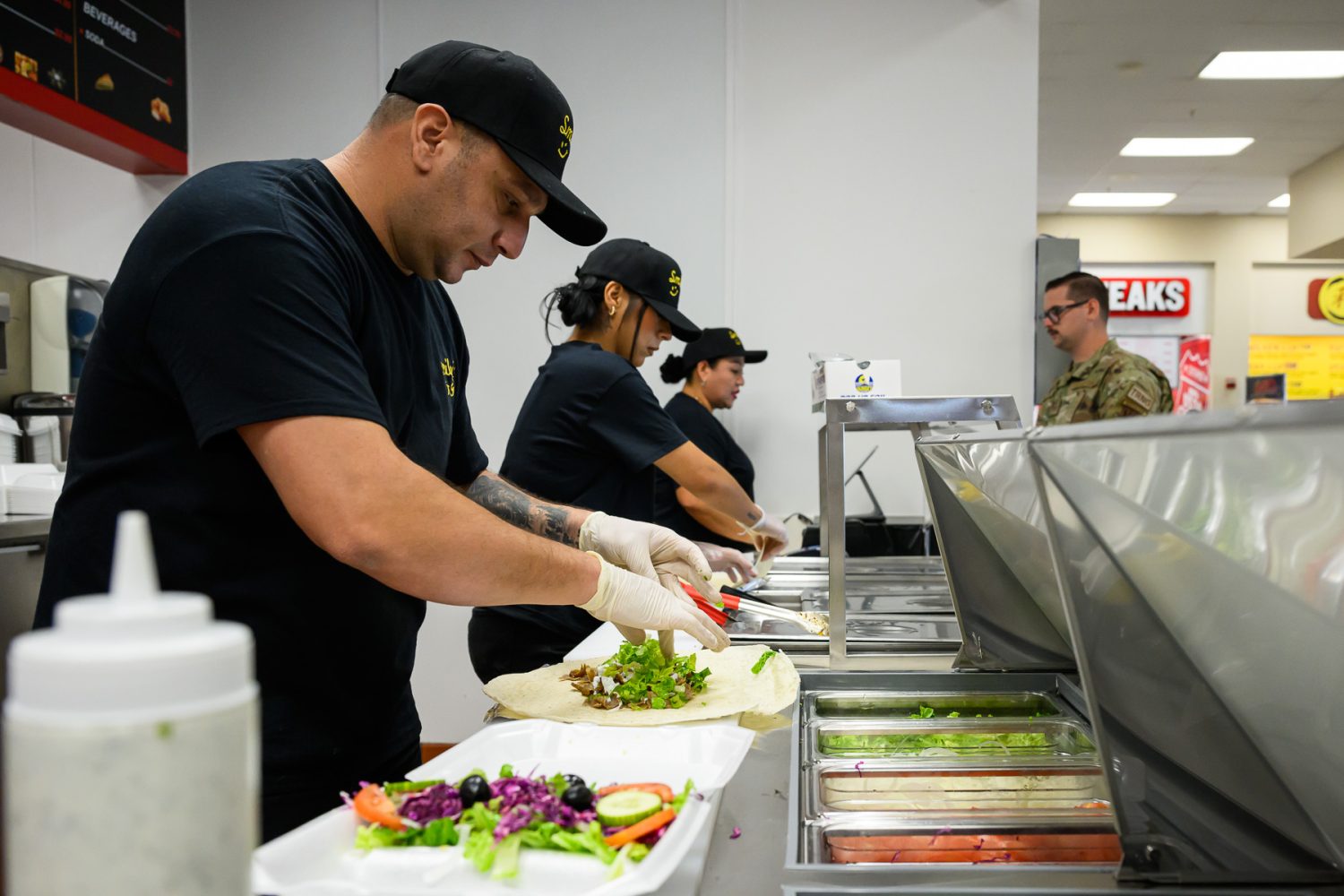 <b>Yusuf Güler, Smiley’s Kitchen Mediterranean Grill proprietor, prepares an order at the new Smiley's Kitchen in the Hill BX food court.</b> 