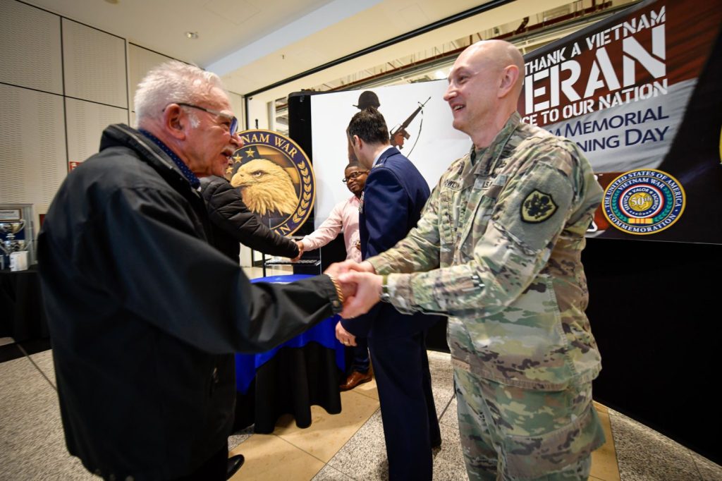 <b>Army Col. Don Nowlin, Commander of the Exchange's Europe, Southwest Asia and Africa Region, greets a Veteran on Vietnam War Veterans Day 2024.</b>