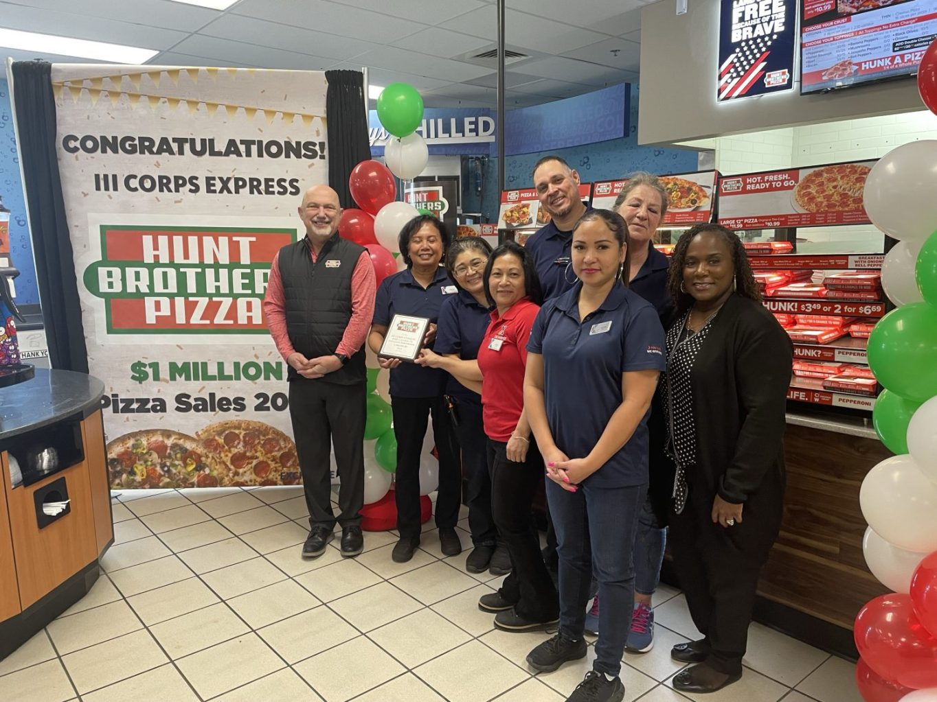 From left: Hunt Brothers Pizza Region District Manager Eddie Langston, Store Manager Eleanora Renguul, Shift Assistant Keiko Hopkins, Shift Manager Ginger Andrike, Roving Store Worker Jennifer Balagot, Shift Manager Guillermo Quiles,  Inventory Control Associate Gabriele Woods and General Manager CJ Morganfield.