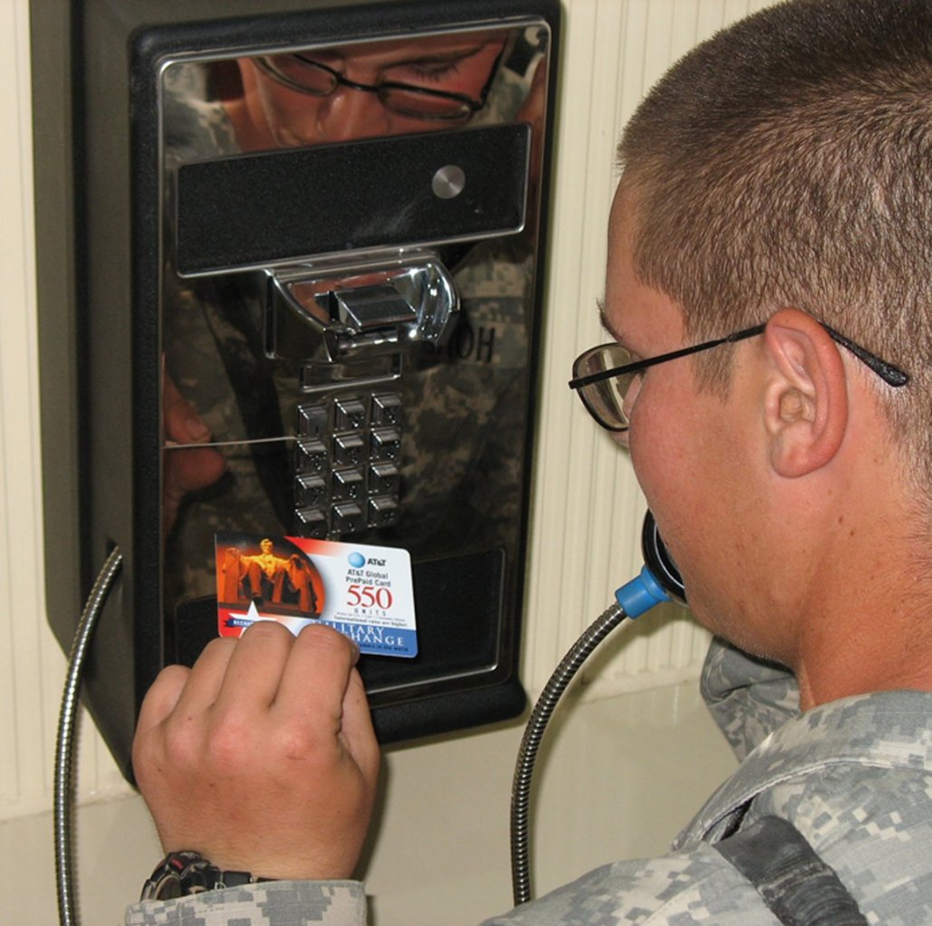 <b>A service member uses a pre-paid phone card to call home from his military installation in the Middle East.</b>