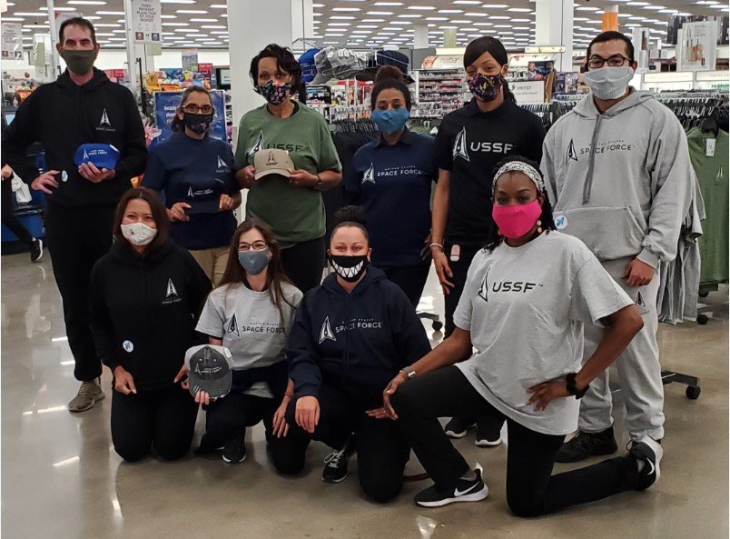 In a 2020 photo, a group of nine masked Buckley Air Force Base associates show off the first T-shirts, sweatshirts and caps to sport the U.S. Space Force logo.