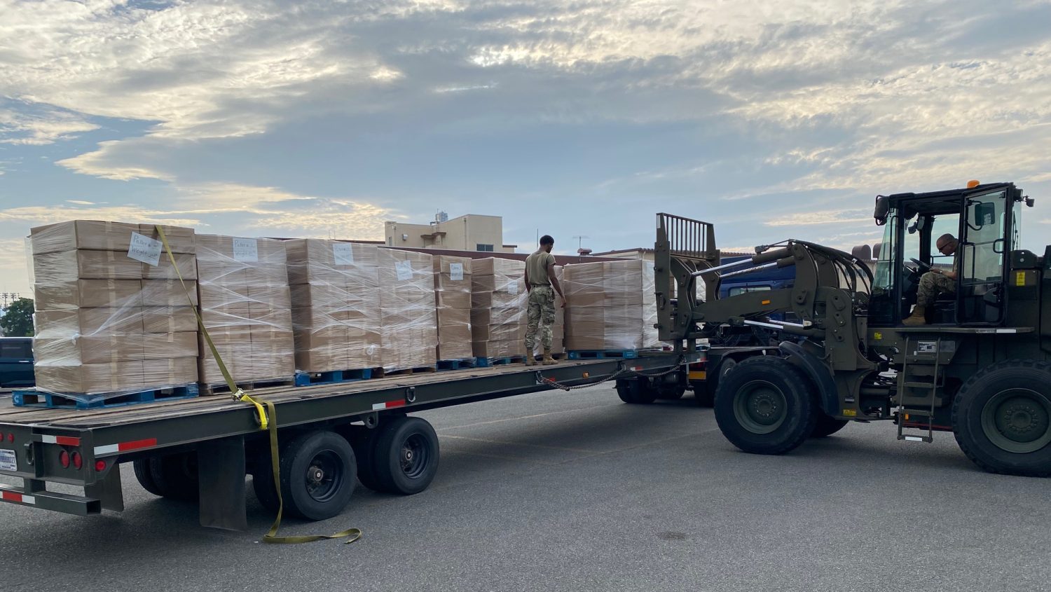 Pictured: A forklift and stacks of boxes on a truck-trailer bed.