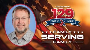 Head shot of Thomas Marsden with American flag background and "129 Years of Family Serving Family" text.