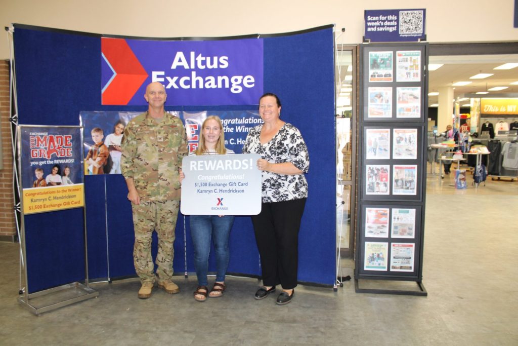 Kamryn Hendrickson accepts her prize in the Exchange’s You Made the Grade program, accompanied by Altus Air Force Base Command Col. Jeffrey Marshall and Exchange General Manager Hollie Heft-Morales.