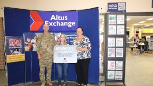 Kamryn Hendrickson accepts her prize in the Exchange’s You Made the Grade program, accompanied by Altus Air Force Base Command Col. Jeffrey Marshall and Exchange General Manager Hollie Heft-Morales.